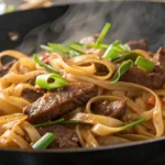 Beef ho fun noodles stir-fry with wide rice noodles and green onions