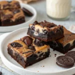Oreo cheesecake brownies with visible marbled swirl and crushed cookie topping